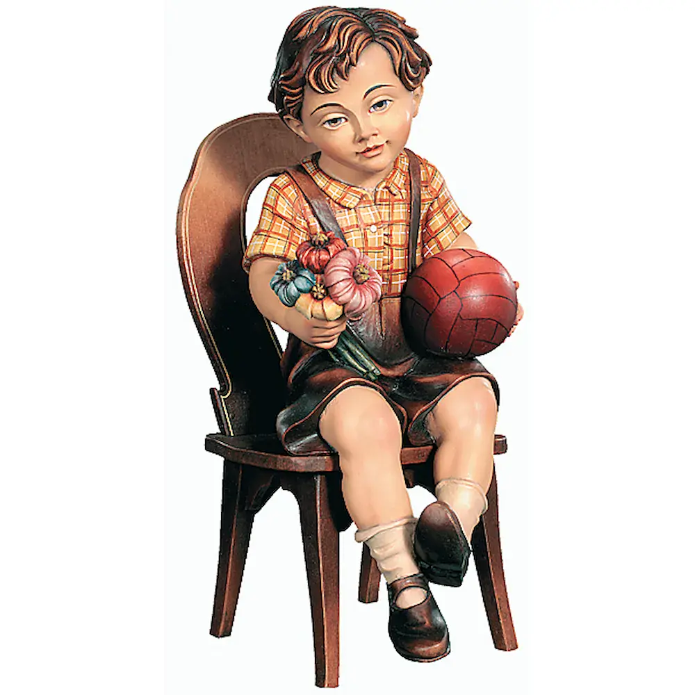 Niño sentado con balón y flores