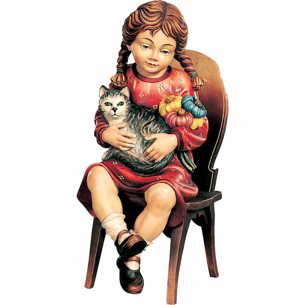 Niña sentada en una silla con gatito y flores