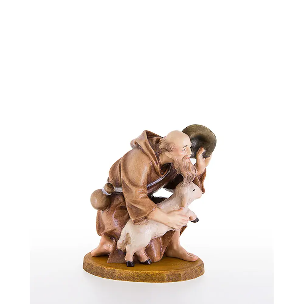 Shepherd kneeling with lamb